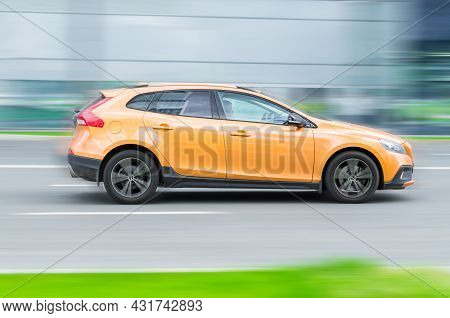 Moscow, Russia - August 2021: Volvo V40 In Fast Motion With Blurred Speedy Background. Orange Color 