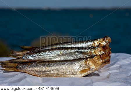 Smoked Sprattus Or Sprats Sea Fish Served Outdoor With View On Blue Sea Water