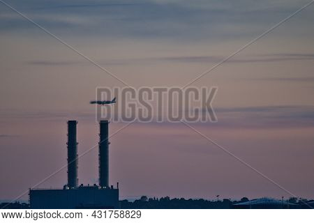 Early Morning View Of Airplane Passing Over Pigeon House Power Station With Visible Heat Air Distort