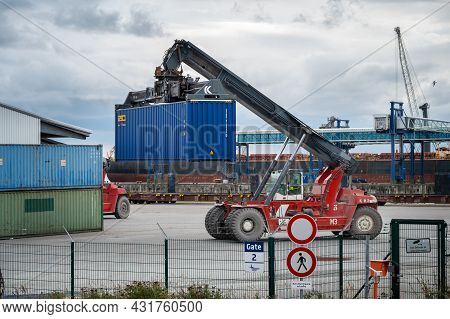 Sassnitz-mukran, Germany, August 20, 2020: Red Shunting Vehicle Is Moving A Heavy Blue Container In 