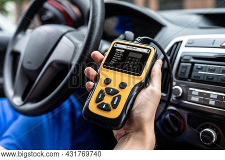 Automobile Service Technician At Car Repair Shop Using Diagnostics Device