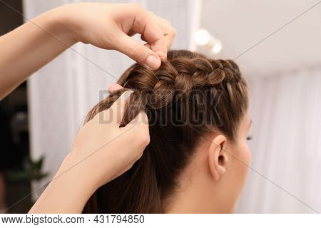 Professional Stylist Braiding Client's Hair In Salon, Closeup