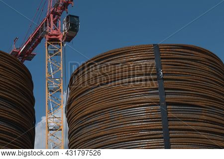 Rolled Rusty Construction Iron In Front Of A Large Construction Crane