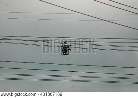 A Man Safely Working An Extremely Dangerous Job Inspecting High-voltage Power Lines