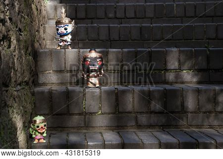 Ravana, Giantess And Hanuman. Standing On A Stone Stairway With Light Shining Down. Traveller Doll.