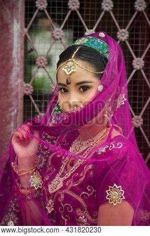 Portrait Asian Woman In A Margenta Indian Tradition Sari, She Is Looking At Down At Side A Wrought I