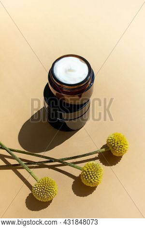 Jars With Creme For Face And Craspedia Globose Flowers On Beige Background. Natural Cosmetics Mockup