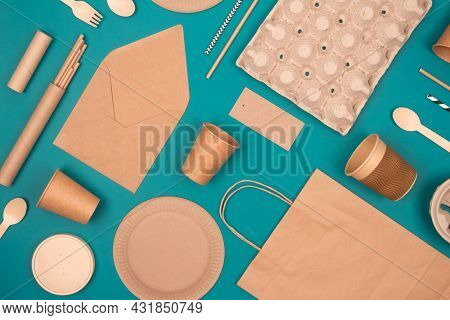 Flat Lay With Eco-friendly Tableware And Sustainable Packaging. Kraft Paper Food Packaging On Green 