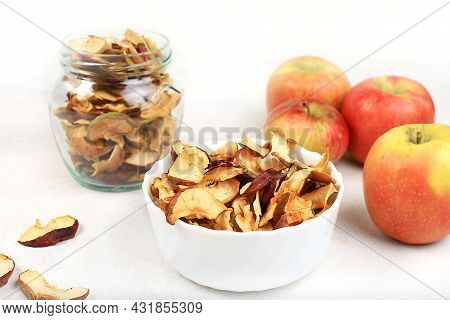Homemade Apple Chips In A Cup And A Jar Of Apples On A White Background, In The Fall Apples Are Bake