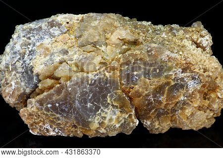 Sample Of Untreated Chalcedony Nodule With Clay Impurities On A Black Background Close Up. Deposit R
