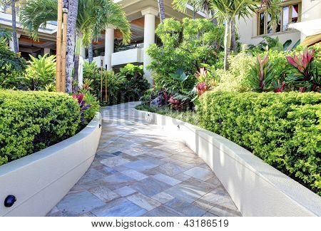 Exterior do edifício do Resort tropical com passarela no jardim.