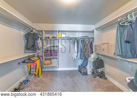 Large Walk-in Closet With A Few Clothes On The Open Shelving Unit
