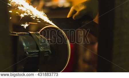 Sharpen The Knife On The Abrasive Wheel, Sparks Fly From Grinding Metal.