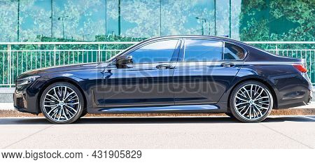 Bmw 745le G11 Standing Next To Building With Glass Facade, Side View. Moscow, Russia - August 2021