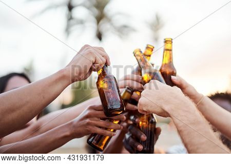Close Up Of The Hands Of A Group Of Friends Cheering With Beer Outside. Concept Of Summer, Friends, 