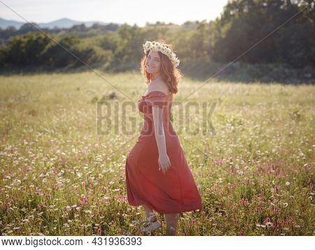Red-haired Woman On A Field On A Summer Evening