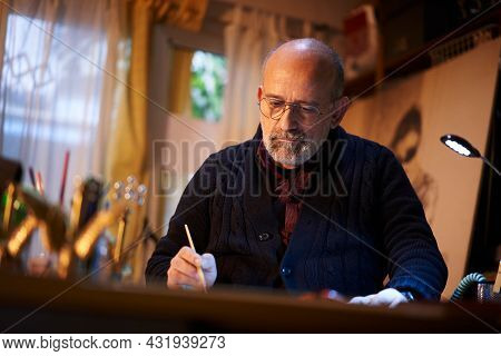 Artist Working In Studio. Middle-aged Man Making Creative Artwork, Painting In Watercolor With Brush
