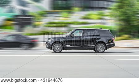 Range Rover L405 Side View. Premium Suv Black Color Driving Against A Background Of Urban Buildings.