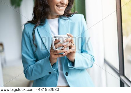 Close-up Of The Hands Of A Young Woman Unrecognizable In Formal Attire Holding A Cup Of Coffee In Fr