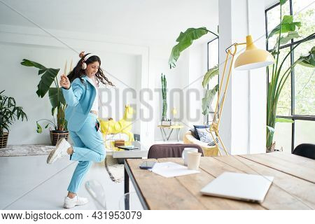 Successful Latina Businesswoman Dances In Office Dress Celebrating Happily At Work.