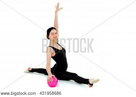 Flexible Teenage Girl Doing Gymnastic Split With Ball. Portrait Of Beautiful Girl Gymnast In Black B