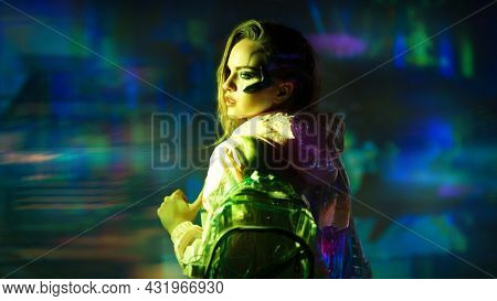 Virtual reality, city of the future. Beautiful cyber girl in hi-tech clothes of the future stands in the neon light of the night cyber city.