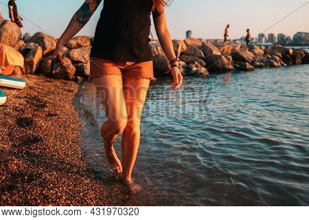 A Woman With A Club Foot Steps On The Seashore. Legs Close-up. The Concept Of Clubfoot And Arthritis