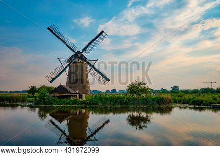 Netherlands rural lanscape with windmills at famous tourist site Kinderdijk in Holland on sunset with dramatic sky