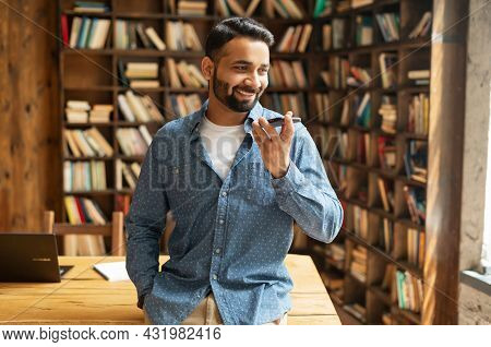 Smiling Indian Man Using Convert Voice Into Text Mobile App, Holding Smartphone, Talking Into A Mic.