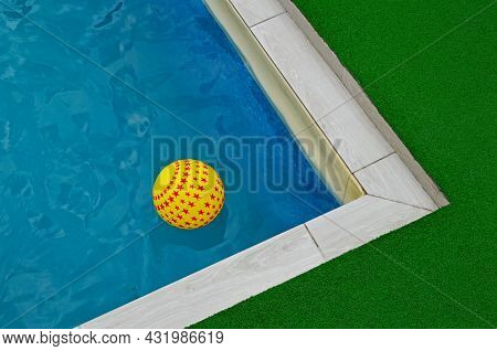 A Yellow Asterisk Ball Floats On The Surface Of The Water In The Pool