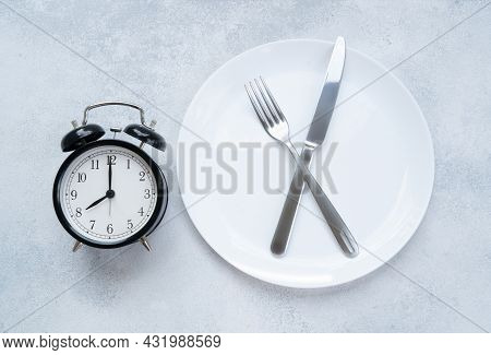 Intermitted Farsting Diet Concept - Empty Plate With Fork And Knife And Timer
