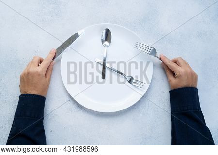 Intermitted Farsting Diet Concept - Empty Plate And Hands With Fork And Knife