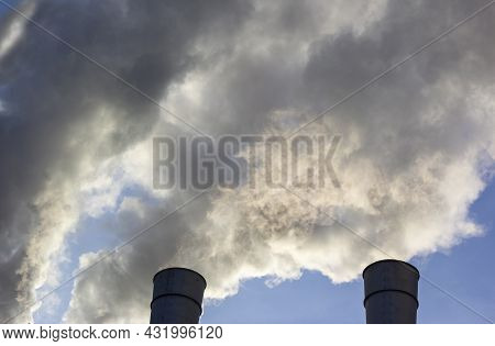 Air Pollution By Smoke Coming Out Of Two Factory Chimneys. Close-up From Below Of Smoke Coming Out O