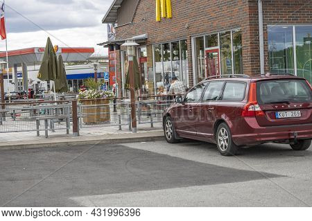 Exterior View Of Mcdonald's Near Okq8 Gasoline Station. Family Has Dinner At Table. Sweden. Uppsala.