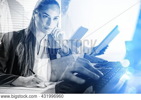 Pondering Businesswoman Is Taking Notes On A List Of Paper. Businessman Is Typing On Keyboard And Ho