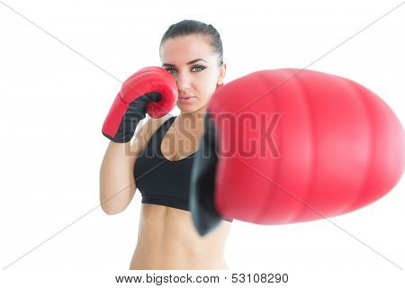 Sporty young woman posing wearing boxing gloves looking at camera