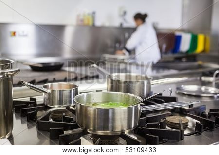 Different pots cooking on hotplate in professional kitchen