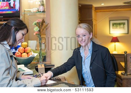 Receptionist Helping A Hotel Guest Check In