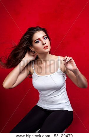 Girl with flying hair on red background