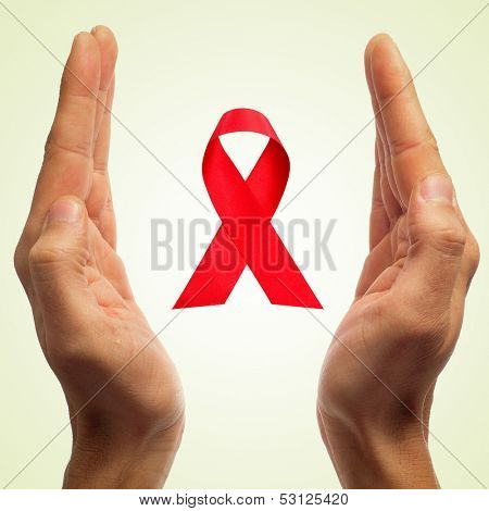 man hands and a red ribbon for the fight against AIDS