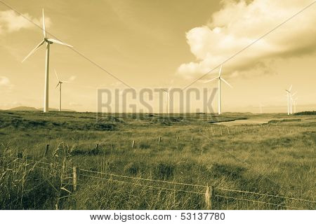 Long Grass And Bogland With Wind Turbines In Sepia