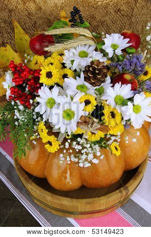 Beautiful autumn composition in pumpkin on table on brown background