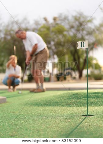 senior couple playing mini golf