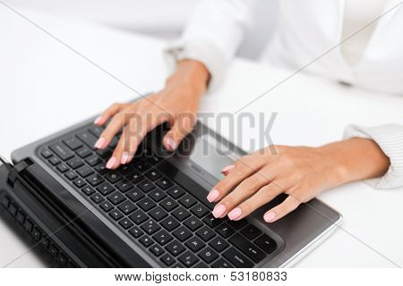 office, business, technology and internet concept - businesswoman using her laptop computer