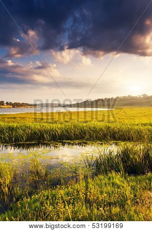 Beautiful view of sinuous river in summer. Dramatic overcast sky. Southern Buh River, Ukraine, Europe. Beauty world.