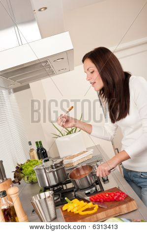 happy Woman Tomatensoße in der Küche kochen