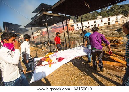 KATHMANDU, NEPAL - DEC 3, 2013: Unidentified local people during the cremation ceremony along the holy Bagmati River in Bhasmeshvar Ghat at Pashupatinath temple in Kathmandu.