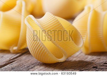 Dry Italian Pasta Lumaconi Scattered On The Old Desk