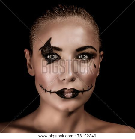 Closeup portrait of terrifying witch with spooky painted face and torn mouth isolated on black background, Halloween holiday concept