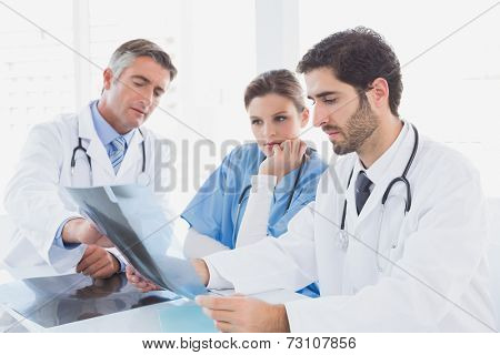 Doctors sitting together with x-rays and discussing resutls